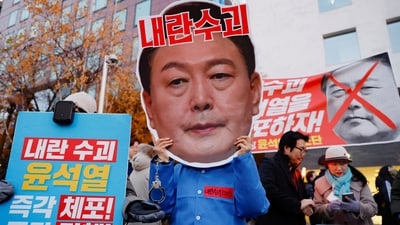 A protestor wears a cut-out of South Korean President Yoon Suk Yeol in a rally calling for his impeachment, who declared martial law, which was reversed hours later, near the National Assembly in Seoul, South Korea. (REUTERS)