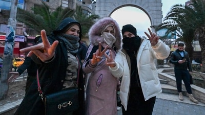 Local residents cheer as the gather on a street in the Damascus suburb of Jaramana. (AFP) Local residents cheer as the gather on a street in the Damascus suburb of Jaramana. (AFP)