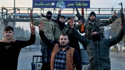Syrian rebel fighters celebrate at the entrance of Homs province early on December 8, 2024, (AFP) Syrian rebel fighters celebrate at the entrance of Homs province early on December 8, 2024, (AFP)