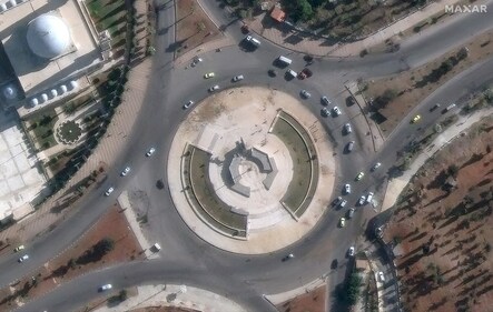 A toppled statue of Bassel al-Assad lies on the ground in Aleppo as rebels announce the ouster of the Syrian president. (Reuters)