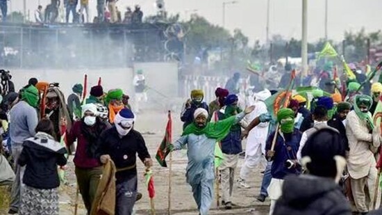 Farmers cover their faces with cloth as police fire tear gas during a protest at the Punjab-Haryana state Shambhu border in Punjab on Sunday. (HT_PRINT)