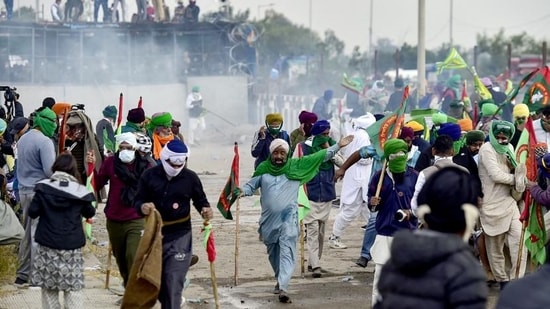 Farmers cover their faces with cloth as police fire tear gas during a protest at the Punjab-Haryana state Shambhu border in Punjab on December 8, 2024. (AFP)