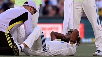 Jasprit Bumrah (R) receives treatment to his leg on the second day of the second Test cricket match between Australia and India at the Adelaide Oval. (AFP) Jasprit Bumrah (R) receives treatment to his leg on the second day of the second Test cricket match between Australia and India at the Adelaide Oval. (AFP)