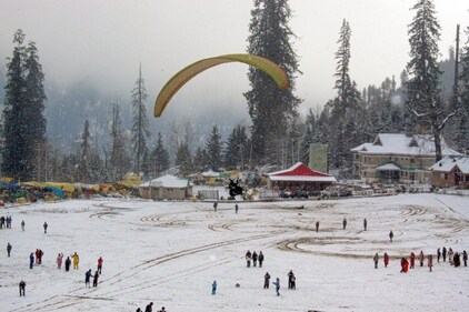 Manali: Tourists participate in paragliding amidst fresh snowfall in Solang valley, in Manali district on Monday. (PTI)