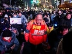 A protester carries a sign that reads "Impeach Yoon Suk Yeol" during a rally calling for the impeachment of South Korean President Yoon Suk Yeol, who declared martial law, which was reversed hours later, in front of the National Assembly in Seoul, South Korea, December 10, 2024. 