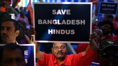 A member of the Hindu Hitarakshana Vedike holds a placard during a protest at Freedom Park in Bengaluru on December 4 against the violence on Hindu minority community in Bangladesh. (AFP) (AFP) A member of the Hindu Hitarakshana Vedike holds a placard during a protest at Freedom Park in Bengaluru on December 4 against the violence on Hindu minority community in Bangladesh. (AFP) (AFP)