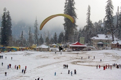 Manali: Tourists participate in paragliding amidst fresh snowfall in Solang valley, in Manali district on Monday. (PTI)