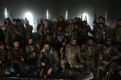 Armed rebel fighters pose for a picture on the burnt gravesite of Syria's late president Hafez al-Assad at his mausoleum in the family's ancestral village of Qardaha in the western Latakia province on December 11, 2024, after it was stormed by opposition factions and set ablaze. (AFP) Armed rebel fighters pose for a picture on the burnt gravesite of Syria's late president Hafez al-Assad at his mausoleum in the family's ancestral village of Qardaha in the western Latakia province on December 11, 2024, after it was stormed by opposition factions and set ablaze. (AFP)