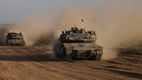 An Israeli soldier gestures from the top of army vehicle near the Israeli border fence with the Gaza Strip, on December 10, 2024, as the war between Israel and Hamas continues in Gaza. (Photo by Menahem KAHANA / AFP) (AFP)