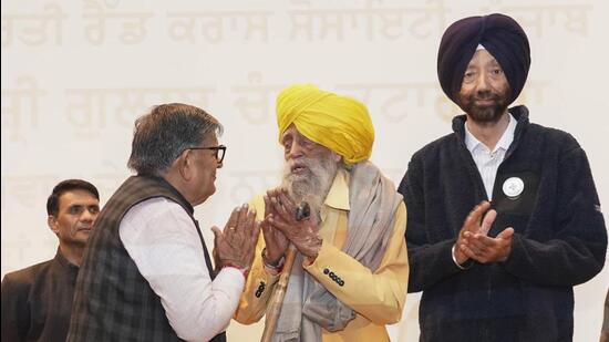 Punjab governor Gulab Chand Kataria honours to veteran marathon runner Fauja Singh during an event against drug abuse, in Jalandhar. (PTI)