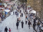 People walk on a snow covered road after fresh snowfall in Shimla. (PTI)