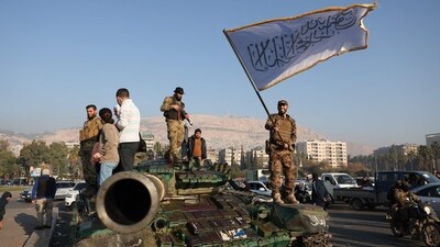 An anti-government fighter waves an Islamic flag from atop a tank in Damascus. (AFP) An anti-government fighter waves an Islamic flag from atop a tank in Damascus. (AFP)