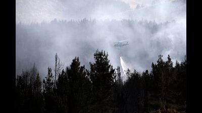 An Army helicopter drops water on a burned pine forest in Latacunga, Cotopaxi Province, Ecuador, on September 27, 2024. (Photo by Galo Paguay / AFP) (AFP) An Army helicopter drops water on a burned pine forest in Latacunga, Cotopaxi Province, Ecuador, on September 27, 2024. (Photo by Galo Paguay / AFP) (AFP)