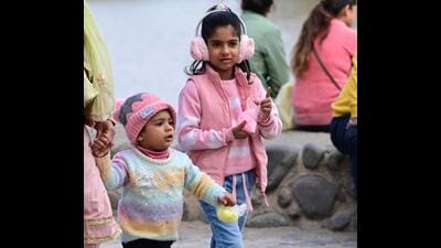Children bundled up in woollens at Sukhna Lake in Chandigarh on Friday. (Keshav Singh/HT)