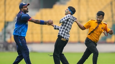 Bengaluru: Baroda's Hardik Pandya, left, reacts as a pitch invader being taken off field by ground staff during the first semi-final T20 cricket match of the Syed Mushtaq Ali Trophy (PTI) Bengaluru: Baroda's Hardik Pandya, left, reacts as a pitch invader being taken off field by ground staff during the first semi-final T20 cricket match of the Syed Mushtaq Ali Trophy (PTI)