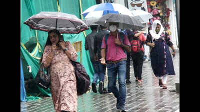 People holding umbrellas at Brigade Road, following heavy rain in Bengaluru (HT PHOTO)