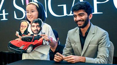 World chess champion Gukesh Dommaraju poses for a photo with a young fan during a meet and greet session in Singapore on Friday. Indian teen prodigy Gukesh became the youngest undisputed world chess champion after beating China's Ding Liren. (AFP) World chess champion Gukesh Dommaraju poses for a photo with a young fan during a meet and greet session in Singapore on Friday. Indian teen prodigy Gukesh became the youngest undisputed world chess champion after beating China's Ding Liren. (AFP)