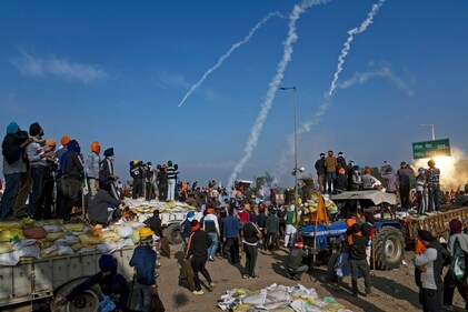Protesting farmers look at smoke trails made by falling tear gas shells used by the police near Shambhu border that divides northern Punjab and Haryana states, India, Feb.21, 2024. (AP Photo/Altaf Qadri) (AP) Protesting farmers look at smoke trails made by falling tear gas shells used by the police near Shambhu border that divides northern Punjab and Haryana states, India, Feb.21, 2024. (AP Photo/Altaf Qadri) (AP)