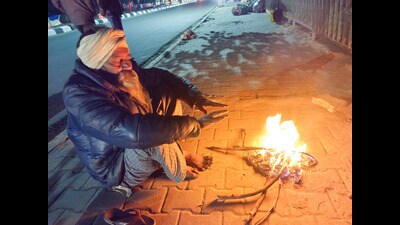 A man sits near a bonfire on a cold winter evening in Patiala on Friday. (ANI)