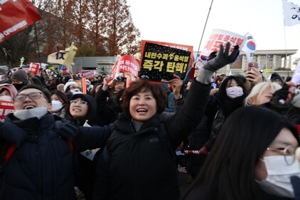 Demonstrators react after lawmakers passed a motion to impeach South Korean President Yoon Suk Yeol during a protest outside the National Assembly in Seoul, South Korea, on Saturday, Dec. 14, 2024. (Bloomberg) Demonstrators react after lawmakers passed a motion to impeach South Korean President Yoon Suk Yeol during a protest outside the National Assembly in Seoul, South Korea, on Saturday, Dec. 14, 2024. (Bloomberg)