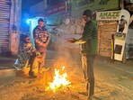 People stand close to the bonfire on a cold winter night at Madanpuri road near Hanuman Mandir, in Gurugram, India, on Sunday People stand close to the bonfire on a cold winter night at Madanpuri road near Hanuman Mandir, in Gurugram, India, on Sunday