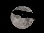 A passenger plane passes in front of the moon near the Fiumicino airport, in Rome, Italy, on December 15.