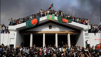 Anti-government protestors display Bangladesh's national flag as they storm Prime Minister Sheikh Hasina's palace in Dhaka on August 5. (AFP) Anti-government protestors display Bangladesh's national flag as they storm Prime Minister Sheikh Hasina's palace in Dhaka on August 5. (AFP)