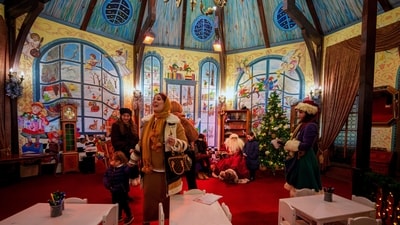 Children get their photo taken with a man wearing a Santa Claus outfit at a Christmas fair in Bucharest, Romania, Saturday. (AP) Children get their photo taken with a man wearing a Santa Claus outfit at a Christmas fair in Bucharest, Romania, Saturday. (AP)