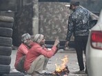 People gather around a bonfire on a cold morning in New Delhi. People gather around a bonfire on a cold morning in New Delhi.