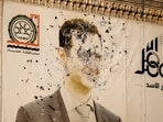 FILE - An image of ousted Syrian President Bashar Assad covers the facade of a provincial government office in the aftermath of the opposition's takeover of Hama, Syria,