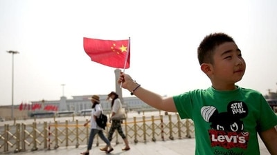 A boy poses with a Chinese national flag in front of Tiananmen Square in Beijing.. (Reuters) A boy poses with a Chinese national flag in front of Tiananmen Square in Beijing.. (Reuters)