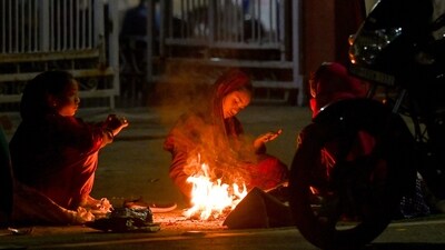 People sit around a bonfire to beat the cold in Noida on December 15, 2024. (Sunil Ghosh/ HT Photo) People sit around a bonfire to beat the cold in Noida on December 15, 2024. (Sunil Ghosh/ HT Photo)