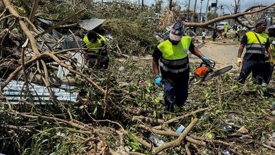 Rescue workers attempt to clear a blocked road, in the aftermath of Cyclone Chido, within Labattoir, in Mayotte, France. (REUTERS)