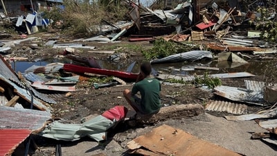 A boy sits near the ruins of homes, in the aftermath of Cyclone Chido, within Labattoir. (REUTERS)