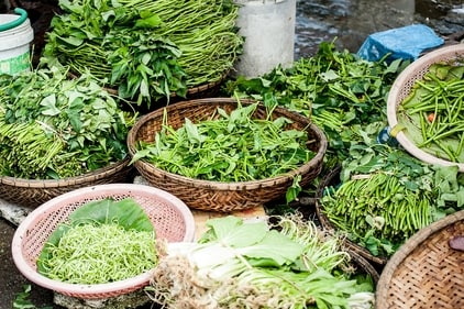 A variety of green leafy vegetables displayed in a baskets in a market in India (unsplash) A variety of green leafy vegetables displayed in a baskets in a market in India (unsplash)