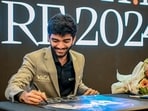 World chess champion Gukesh Dommaraju signs an autograph during a meet and greet session in Singapore after becoming the youngest undisputed world chess champion on December 12.