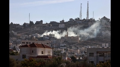 Smoke rises following an explosion amid clashes between Palestinian Authority (PA) security forces and militants in the Jenin camp in the Israel-occupied West Bank on December 15, 2024. (Photo by Zain JAAFAR / AFP) (AFP)