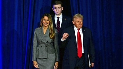 Former US President and Republican presidential candidate Donald Trump (R) arrives for  an election night event alongside former US First Lady Melania Trump and his son Barron Trump at the West Palm Beach Convention Center in West Palm Beach, Florida, on November 6, 2024. (Photo by Jim WATSON / AFP) (AFP)