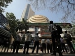 People look at a screen displaying the Sensex results on the facade of the Bombay Stock Exchange (BSE) building in Mumbai.