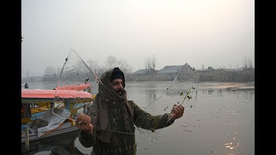 A man shows ice sheets of partially frozen water of Dal Lake in Srinagar on Thursday. (Waseem Andrabi /HT) A man shows ice sheets of partially frozen water of Dal Lake in Srinagar on Thursday. (Waseem Andrabi /HT)