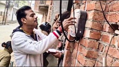 An officer checks electricity reading at the residence of Samajwadi Party MP Ziaur Rehman Barq, in Sambhal, Uttar Pradesh, on Thursday (PTI)