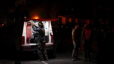 Israeli police bomb squad members work near a damaged site after a projectile fired from Yemen was intercepted, in Ramat Gan, (REUTERS)