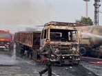 Firefighters extinguish the fire at the site of the accident after a truck loaded with a chemical collided with some other vehicles.