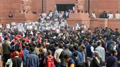 INDI Alliance and BJP MPs protest at the Makar Dwar of the Parliament in New Delhi on Thursday. (ANI Photo) INDI Alliance and BJP MPs protest at the Makar Dwar of the Parliament in New Delhi on Thursday. (ANI Photo)