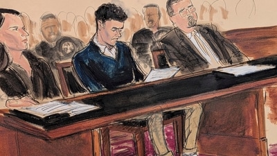 Luigi Mangione, center, sits in court reading the federal complaint while wearing orange slip on shoes and his ankles shackled in Manhattan federal court, Thursday, Dec. 19, 2024, in New York. . He is flanked by his attorneys, Karen Agnifilo, left, and Marc Agnifilo. (Elizabeth Williams via AP) (AP) Luigi Mangione, center, sits in court reading the federal complaint while wearing orange slip on shoes and his ankles shackled in Manhattan federal court, Thursday, Dec. 19, 2024, in New York. . He is flanked by his attorneys, Karen Agnifilo, left, and Marc Agnifilo. (Elizabeth Williams via AP) (AP)
