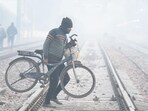 A man carrying his bicycle across railway tracks on a cold winter morning at Daultabad near Railway Station, in Gurugram on December 17. A man carrying his bicycle across railway tracks on a cold winter morning at Daultabad near Railway Station, in Gurugram on December 17.