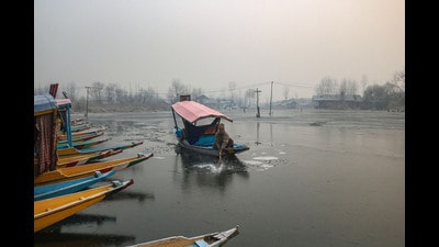 A boatman tries to break the ice sheet on Dal Lake’s surface in Srinagar on Saturday. (Waseem Andrabi /HT) A boatman tries to break the ice sheet on Dal Lake’s surface in Srinagar on Saturday. (Waseem Andrabi /HT)