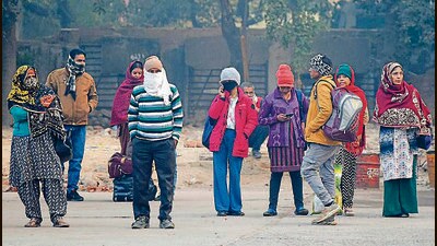 Commuters step out wearing warm clothes on a cold day at the bus stand near Police Lines in Gurugram on Saturday. (Parveen Kumar/Hindustan Times)