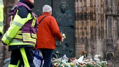 People leave floral tributes by a church near the site where a car drove into a crowd at a Magdeburg Christmas market in Germany. (REUTERS)