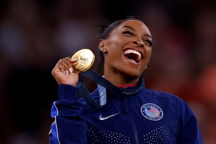 Gold medallist Simone Biles of United States celebrates on the podium with her medal.